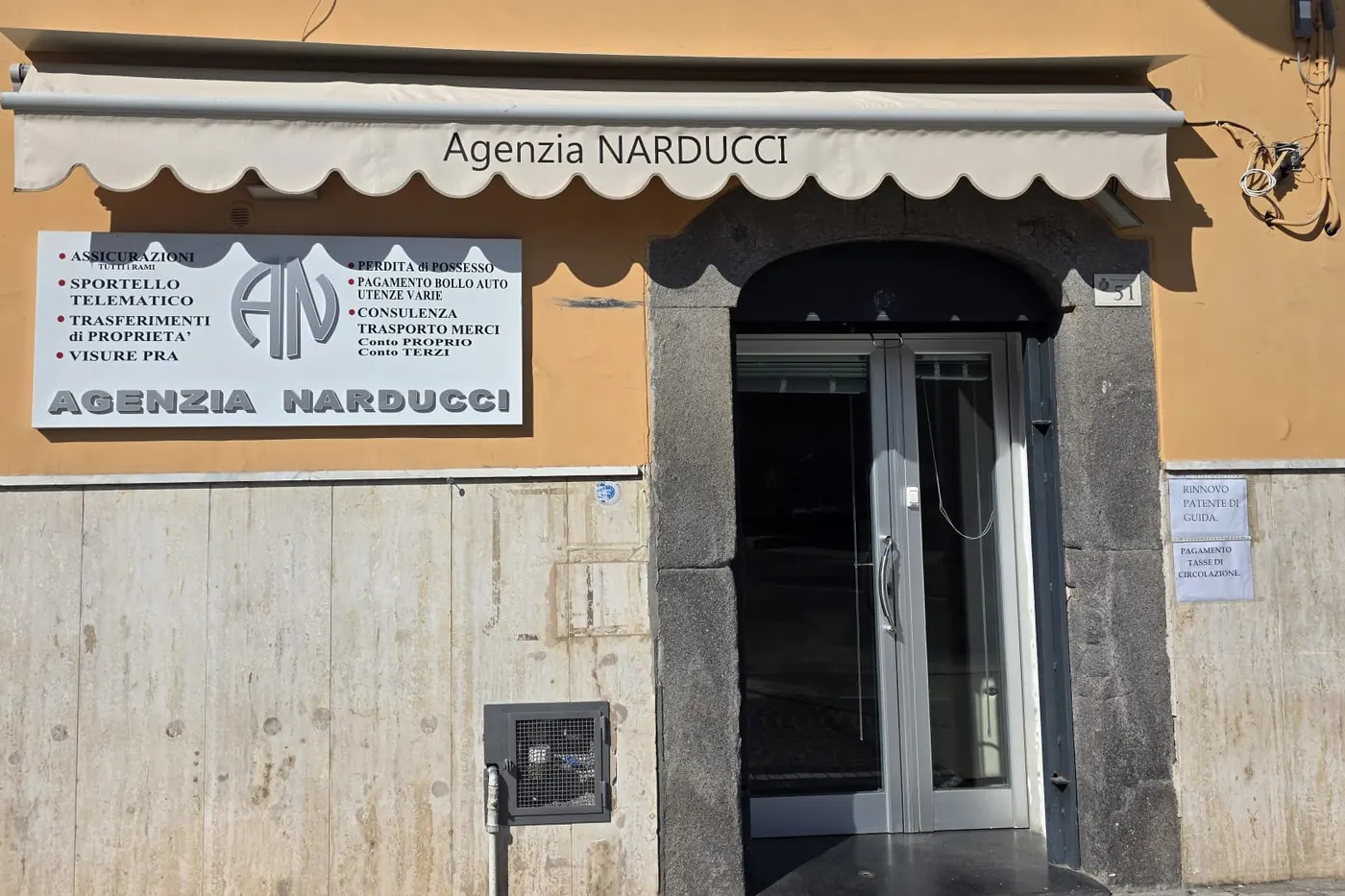 L'ingresso dell'Agenzia Narducci in Via Roma 51 a Pomigliano d'Arco, con la tenda e l'insegna